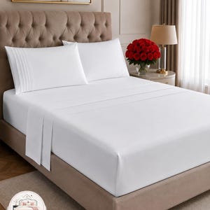 May include: A set of crisp white bed sheets and two matching pillowcases featuring vertical pleated detailing on the edges. The bedding is arranged on a tufted headboard bed frame, creating a clean and uniform appearance for the sleeping surface.