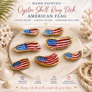 May include: Six oyster shell ring dishes, each hand-painted with the American flag design featuring a blue field with white stars and red and white stripes. The shells have gold-painted edges and are arranged on a circular stone surface.