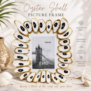 May include: A rectangular picture frame decorated with real oyster shells, each featuring a white interior with a black center and gold-painted edges. The frame holds an 8x10 inch photo of Tower Bridge. Text on the frame includes Oyster Shell Picture Frame.