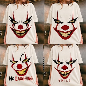Peut inclure: Une collection de quatre t-shirts blanc cassé, chacun arborant une impression graphique d'un visage de clown avec des détails rouges et noirs. Deux t-shirts montrent des visages de clown aux dents acérées, les autres incluent le texte NO LAUGHING ou SMILE en rouge.