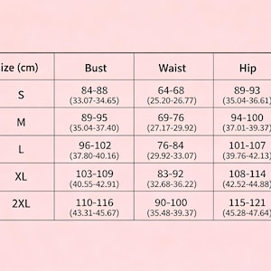 May include: A size chart table on a light pink background with black text. The table lists sizes S through 2XL with corresponding bust, waist, and hip measurements in centimeters and inches. The columns are labeled Size (cm), Bust, Waist, and Hip.