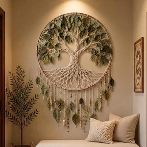 Puede incluir: Un gran tapiz circular para pared con un diseño de árbol de la vida en macramé, con raíces y ramas anudadas. El árbol está adornado con numerosas hojas de tela verde y hebras colgantes con pequeñas cuentas, creando un efecto texturizado.