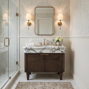 Luxury bathroom featuring a handcrafted Calacatta marble vanity with an integrated sink, bold natural veining, brushed brass fixtures, dark oak cabinet, and timeless designer styling. Premium custom marble vanity for upscale residential interiors.