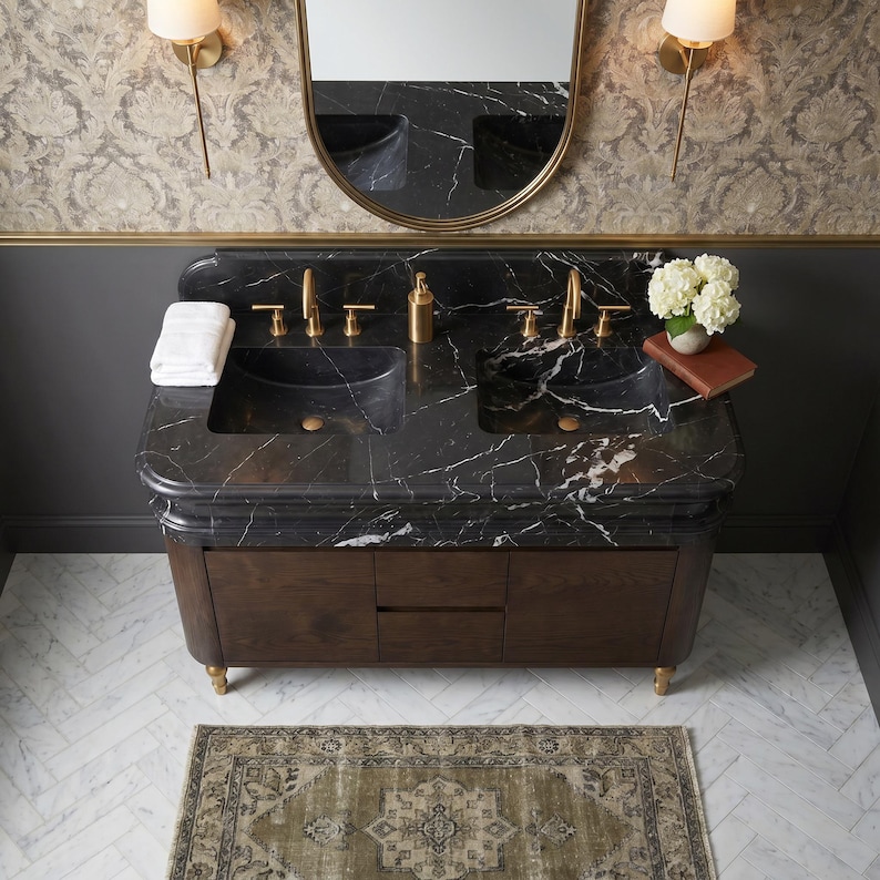 Top-down perspective of a custom Nero Marquina marble double vanity displaying two integrated stone basins, premium black marble with bold white veining, decorative molded edges, matching backsplash, brushed brass hardware, and a dark walnut cabinet designed for sophisticated luxury bathroom interiors.