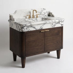 Luxury Calacatta marble bathroom vanity featuring an integrated stone sink, bold gray veining, sculpted backsplash, brushed brass faucet, and solid dark oak cabinet. Handcrafted custom marble vanity designed for elegant master bathrooms, powder rooms, and luxury interiors.
