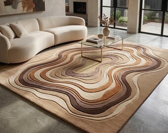 Puede incluir: Una alfombra rectangular grande con un diseño en capas inspirado en la topografía, que presenta bandas onduladas concéntricas en varios tonos de beige, bronceado, crema y marrón oscuro, creando una apariencia texturizada y en relieve.