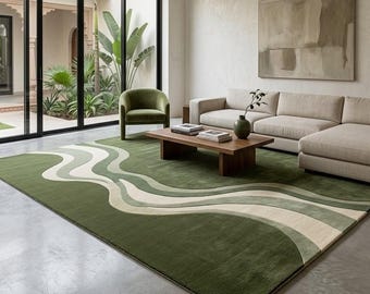 Puede incluir: Una alfombra rectangular grande con un patrón abstracto ondulado en tonos verde bosque, verde salvia y crema. La alfombra tiene una textura suave y afelpada, cubriendo una parte significativa del suelo con líneas fluidas y suaves.