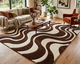 Puede incluir: Una alfombra rectangular que presenta un patrón repetitivo de líneas gruesas, onduladas y fluidas en tonos alternos de marrón oscuro y crema. La alfombra está colocada sobre un suelo de madera clara, cubriendo gran parte del espacio visible.