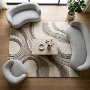 Top angle view of a modern cream and beige organic wave rug featuring layered flowing curves, soft neutral tones and a dimensional textured surface, clearly showing the complete rectangular composition.
