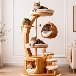 May include: A multi-level wooden cat tree featuring a circular base with a cat-shaped entrance, three carpeted platforms, a hanging woven rattan pod, and a dangling toy ball. Three cats are resting on the various levels of the structure.
