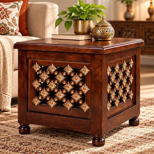 May include: A square wooden end table with a dark brown finish, featuring four bun feet and side panels decorated with a repeating gold-toned floral lattice pattern. The table has a flat top surface and a sturdy, boxy frame construction.