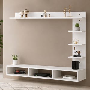 May include: A white wall-mounted entertainment center featuring a long horizontal shelf, a lower console with three open storage compartments, and a vertical side panel with four smaller shelves for displaying decorative items and electronics.