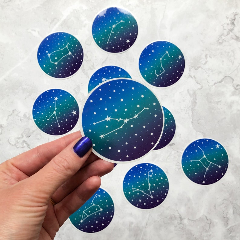 May include: A set of nine blue and purple constellation stickers with white outlines. Each sticker features a different constellation with a white background and a gradient of blue and purple.
