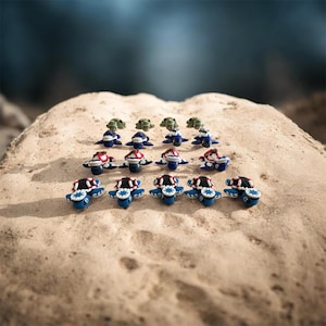 May include: A collection of small, sculpted turtle figurines arranged in rows. The turtles feature blue, white, and black shells with detailed patterns, while some have green shells. Each figurine has a distinct head and flipper design.