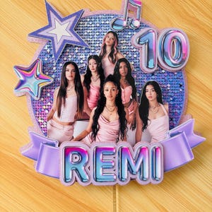 May include: A circular cake topper featuring a blue sequined background with a photograph of five individuals in pink outfits. It includes a large number 10, a musical note, two stars, and a purple banner with the name REMI in metallic lettering.