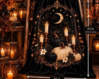 May include: A black throw blanket featuring a central ornate gold frame design with a crescent moon, stars, bats, lit candles in holders, and a cluster of black and white pumpkins. The blanket measures 50 inches wide by 60 inches in height.