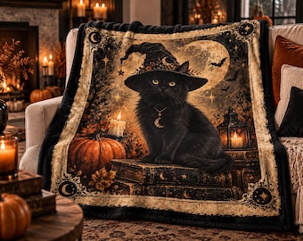 May include: A rectangular throw blanket featuring a black cat wearing a witch hat and a crescent moon necklace. The cat sits on a stack of books next to a pumpkin, a lit candle, and a lantern. The background displays a full moon and stars.