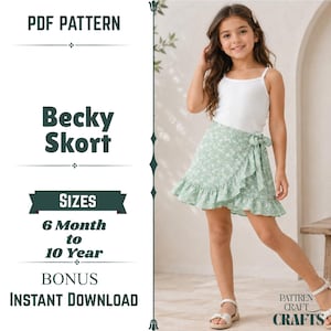 Può includere: Un cartamodello PDF per una gonna-pantalone Becky, taglie da 6 mesi a 10 anni. L'immagine mostra una canotta bianca con una gonna-pantalone a portafoglio verde chiaro con stampa floreale bianca, fiocco laterale e orlo a balze. Testo: PDF PATTERN, Becky Skort, SIZES 6 Month to 10 Year, BONUS INSTANT DOWNLOAD, PATTREN CRAFT CRAFTS.