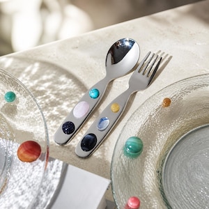 May include: A silver-toned metal spoon and fork set featuring handles inlaid with smooth, polished cabochon stones in various colors including turquoise, pale pink, dark blue, yellow, light blue, and black, arranged in a vertical row.