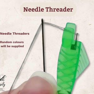 Peut inclure: Un enfile-aiguille en plastique vert avec un motif en losange texturé sur la poignée. L'outil est montré tirant un fil argenté fin à travers le chas d'une aiguille à coudre noire. Le texte indique Needle Threader, 3x Needle Threaders et Random colours will be supplied.