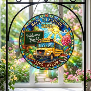 May include: A circular stained glass suncatcher featuring a yellow school bus, a green chalkboard with the text Welcome Back!, a stack of books, and colorful pencils. The text reads BACK TO SCHOOL 2026 and MRS. TAYLOR, with a sun and tree design.