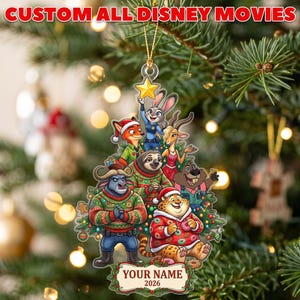 May include: A Christmas tree ornament featuring Zootopia characters in a tree shape, including Judy Hopps, Nick Wilde, Flash, and Clawhauser. The ornament has a yellow star at the top, a banner at the bottom with the text "YOUR NAME 2026", and a gold string.