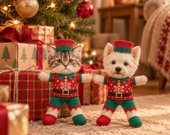 Peut inclure: Deux peluches, un chaton tigré et un chien terrier blanc, vêtus de costumes d'elfe assortis rouges et verts avec des motifs de flocons de neige, des chapeaux verts et des ceintures noires, debout sur une surface texturée.