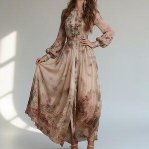 May include: A floor-length beige dress featuring long, billowy sleeves with cuffed wrists, a high neckline, and a central front slit. The garment is adorned with a soft, muted floral print in shades of brown, pink, and green throughout the fabric.