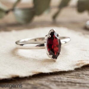 Anillo de compromiso solitario de plata de ley con granate talla marquesa, piedra natal de enero.