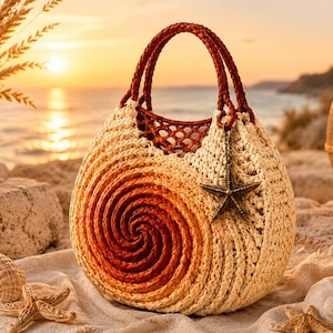 May include: A round, crocheted handbag featuring a spiral pattern that transitions from cream to deep orange. The bag has two braided dark brown handles and a metallic starfish charm attached to the front. The texture is woven and intricate.