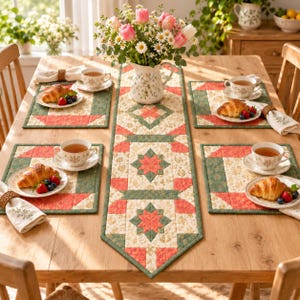 Puede incluir: Una mesa de comedor de madera con un camino de mesa acolchado y cuatro manteles individuales a juego con motivos florales en coral, verde salvia y crema. Cada servicio incluye una taza de té blanca, un cruasán con bayas y una servilleta bordada.