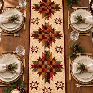 May include: A rectangular quilted table runner featuring a repeating star pattern in shades of red, green, and gold on a cream background. The runner is bordered by a thin dark red trim and displays intricate stitching throughout the fabric surface.