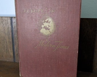 May include: A burgundy hardcover book with gold lettering titled "Europe in Modern Times". The cover features a gold illustration of a map of Europe.