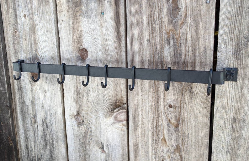 Rack is shown complete with 8 standard, movable hooks, mounted on a barnwood wall.