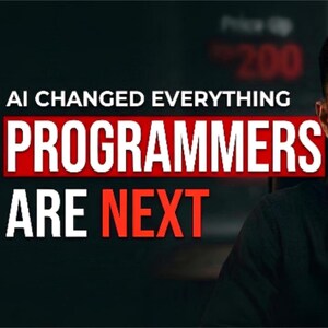 Op de afbeelding: Een persoon in een zwart overhemd met kraag voor een microfoon. De tekst AI CHANGED EVERYTHING PROGRAMMERS ARE NEXT staat in witte en rode letters aan de linkerkant van het frame tegen een donkere achtergrond.