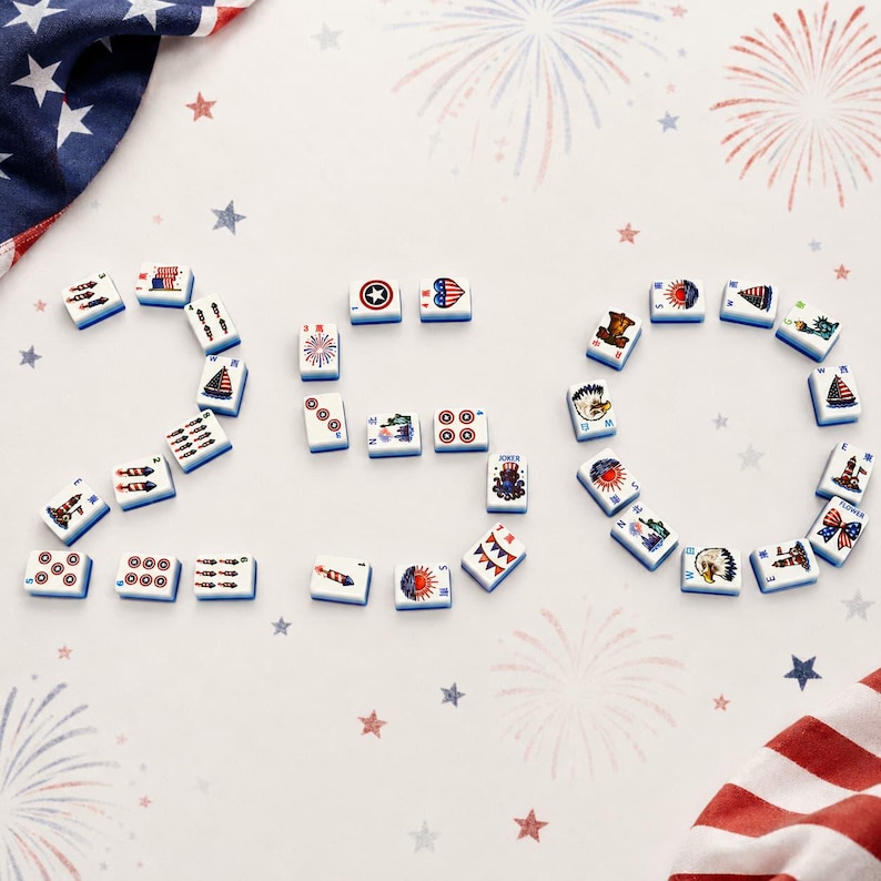May include: A collection of white rectangular mahjong tiles arranged to form the number 250. Each tile features colorful patriotic graphics including American flags, eagles, fireworks, and lighthouses, set against a background with firework motifs.