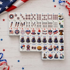 May include: A set of white mahjong tiles featuring patriotic American-themed illustrations including stars, fireworks, eagles, the Statue of Liberty, and various red, white, and blue icons. Each tile displays specific numbers, letters, or labels.