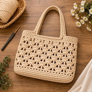 Könnte beinhalten: Eine beige Häkeltasche mit einem komplizierten, durchbrochenen Blumenmuster, zwei stabilen Tragegriffen und einem festen Boden. Die Tasche ist aus dickem Garn gefertigt und weist ein gleichmäßiges Maschenbild am Körper und den Griffen auf.