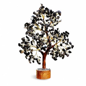 Könnte beinhalten: Eine dekorative Baumskulptur mit einem braunen Stamm und einem zylindrischen Sockel. Die Äste bestehen aus dünnem, goldfarbenem Draht, der mit zahlreichen kleinen, unregelmäßigen, polierten schwarzen Steinen als Blätter besetzt ist.