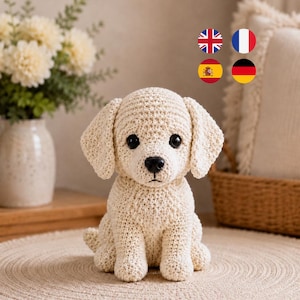 May include: A cream-colored crochet puppy figurine with large black plastic eyes and a black nose. The dog is sitting in an upright position with floppy ears and a textured yarn surface. The design features a simple, rounded head and body.