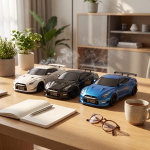 May include: Three sports car-shaped humidifiers in white, black, and blue, each featuring a rear spoiler and a digital clock display on the front bumper showing 07:00. Wisps of white mist rise from the top of each vehicle, which are arranged on a wooden surface.
