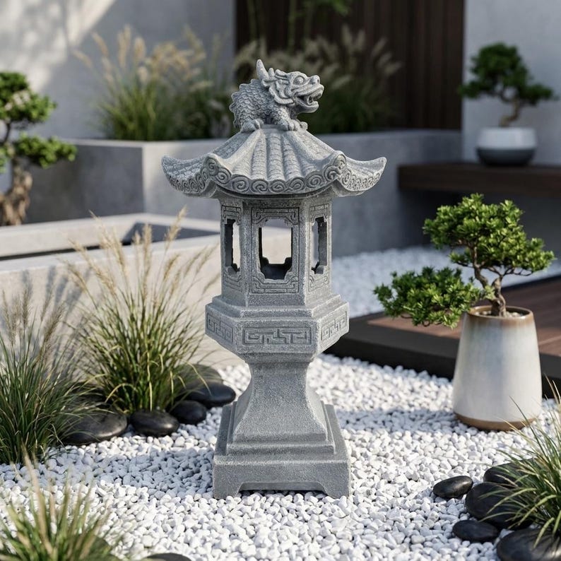 May include: A gray stone garden lantern featuring a hexagonal base, a central chamber with open windows, and a tiered roof topped with a sculpted mythical creature. The structure displays intricate geometric carvings along the midsection.