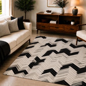 Alfombra de cuero con estampado geométrico de espiga y pelo, 152 x 244 cm, hecha a mano, color negro y marfil.