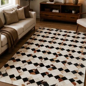 May include: A rectangular area rug featuring a repeating checkerboard pattern composed of individual square patches. The design alternates between solid black, solid white, and natural brown and white cowhide-textured squares.