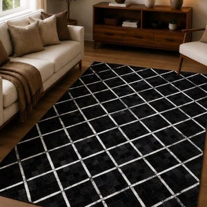 May include: A rectangular area rug featuring a black patchwork design composed of small square tiles. The rug is overlaid with a prominent white grid pattern that creates a diamond effect across the entire surface of the floor covering.