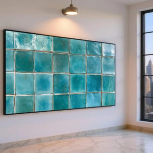 Peut inclure: Une grande œuvre d'art murale rectangulaire présentant une grille de carreaux carrés turquoise brillants avec des variations subtiles de couleur et de texture, encadrée d'un fin bord noir, affichée horizontalement sur un mur blanc.
