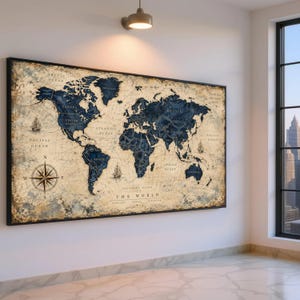 May include: A large rectangular wall art print featuring a world map with deep blue landmasses against a distressed, aged parchment-coloured background. The map includes a compass rose, illustrations of sailing ships, and the text THE WORLD.