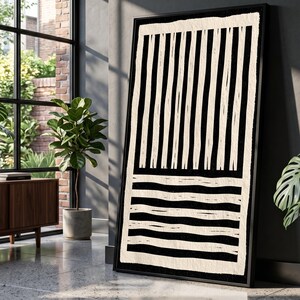 Può includere: Una grande opera d'arte murale rettangolare incorniciata con un design ad alto contrasto in nero e bianco sporco. La sezione superiore mostra strisce verticali, mentre quella inferiore presenta linee ondulate orizzontali con un effetto pennellata.