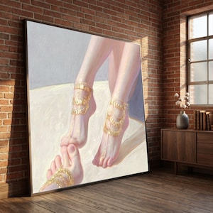 May include: A large rectangular wall art piece featuring an oil painting of two feet adorned with intricate gold chain anklets. The artwork displays soft pink skin tones against a light cream and grey background, capturing a detailed close-up view.