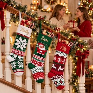 May include: Three personalized Christmas stockings hanging from a wooden staircase railing. The first is green and white with a snowflake pattern and the name Molly. The second is green with a Santa graphic and the name Sam. The third is red and white with a reindeer pattern and the name Lily.